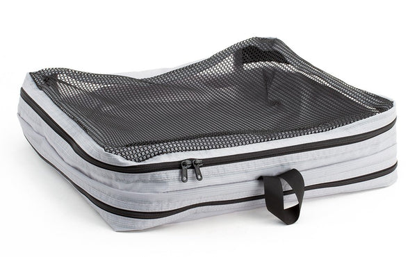 An empty and zipped closed Northwest Sky (light grey) Aether Large Laundry Aeronaut 45 Packing Cube mesh side up.